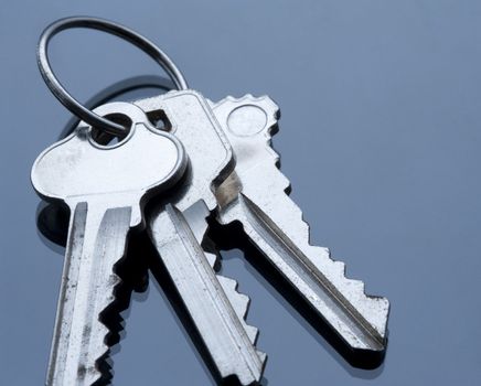 three keys on a keyring with cold coloured lighting, concept of security