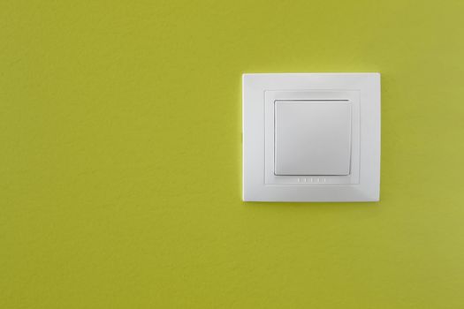 Simple light switch on a green wall 