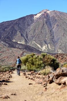 Tenerife. Walking on Teide, Tenerife. Woman hiking on path on the volcano Teide. Focus on the volcano.