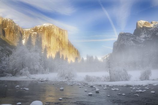 Alpenglow on the granite peaks in Yosemite valley with mist rising above the merced river