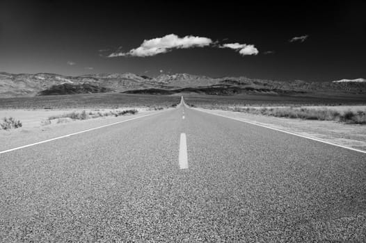 Black & white of the Road across Death Valley with clouds on the horizon