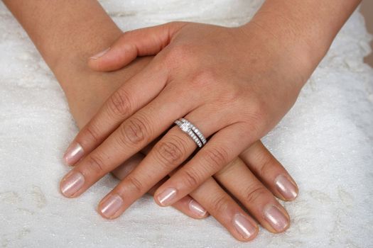 Asian bride's hands rested on white gown