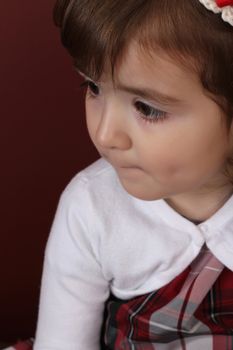 Cute little brunette toddler with serious expression