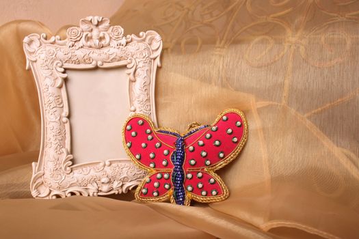 Empty Picture frame and a red beaded butterfly