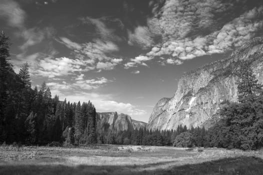 Yosemite valley as the sun is rising in monochrome with beautiful clouds formations overhead