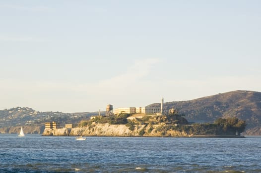 Alcatraz island at sunset, with sail boats in the bay