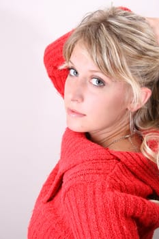 Blonde model tying her hair, wearing a red top