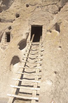 Ancient Anasazs or Puebloan indian dwelling at Bandelier in New Mexico, with ladder going up to the entrance of the Kiva