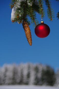 red bauble christmas ball ornament outside in a snowy winter scene