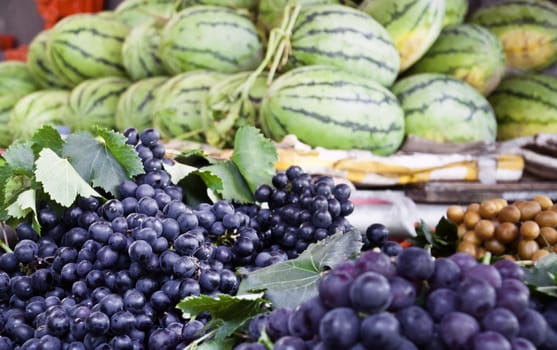 Blue grapes in a local market with fruit around