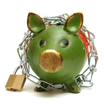 A conceptual shot of an isolated piggy bank that is bound by chains to give representation to protecting your money.