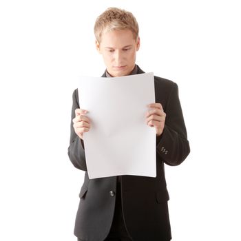 Successful young businessman reading blank card (newspaper) in studio