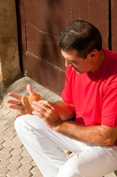 Traditional Spanish pelota player ritually wrapping his fingers in plaster protections