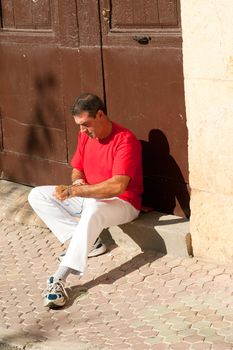 Traditional Spanish pelota player ritually wrapping his fingers in plaster protections