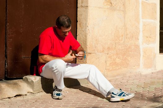 Traditional Spanish pelota player ritually wrapping his fingers in plaster protections