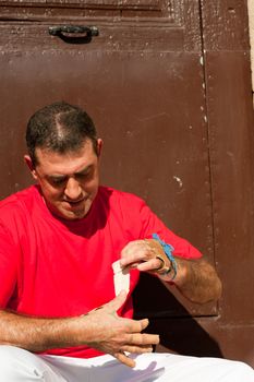 Traditional Spanish pelota player ritually wrapping his fingers in plaster protections