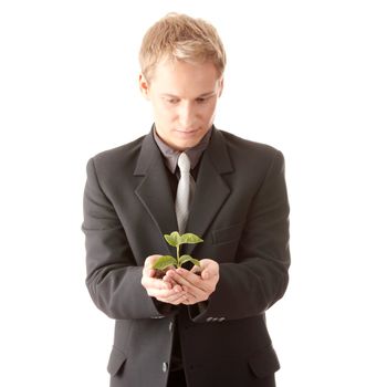 Businessman in dark suit holding smal plant in his hands - growth concept