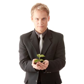 Businessman in dark suit holding smal plant in his hands - growth concept