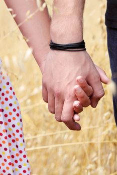 Young couple in grain field - hands