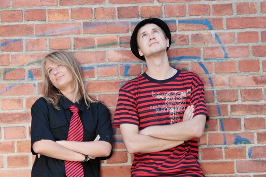 Young punk couple against brick wall