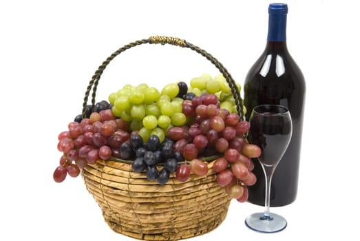 Three different kinds of seedless grapes in a handmade basket and wine