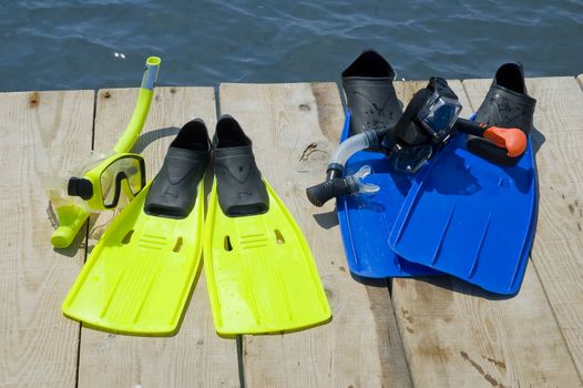 Colorful flippers on a pier near the ocean