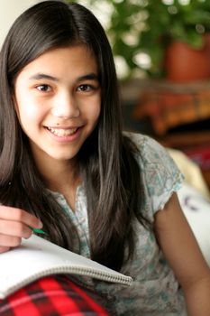 Young teen writing in notebook