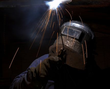 a welder working at shipyard at night