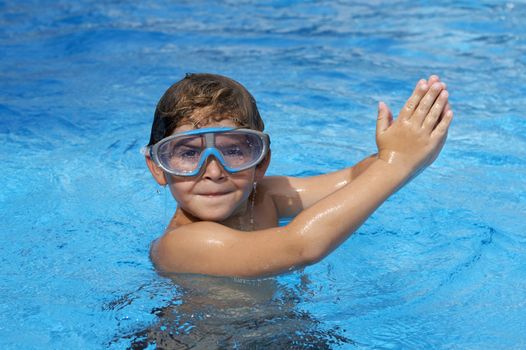 a young boy in pool with goggles on