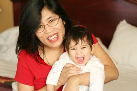 Asian mother and baby waking up with smiles