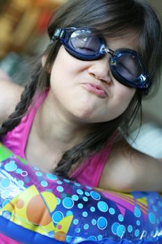 Child making funny expression by pool