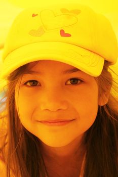 Beautiful little girl playing inside a yellow tube at playground