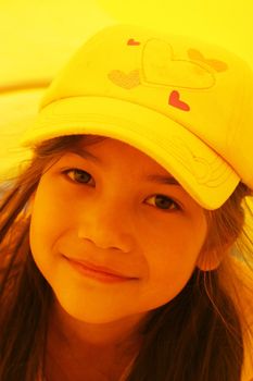 Beautiful little girl playing inside a yellow tube at playground