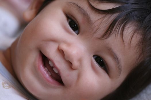 Happy baby boy smiling, part Scandinavian,Thai background