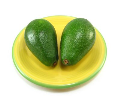 image of two avocados on a yellow plate