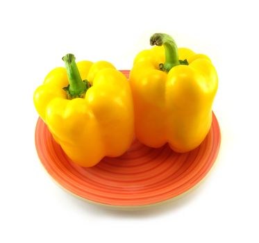image of two yellow peppers on a red plate