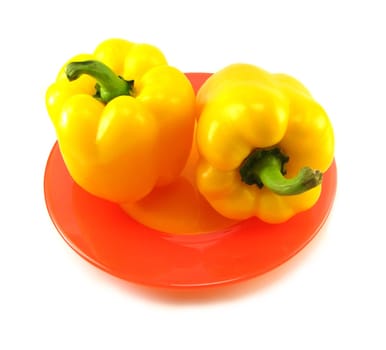 image of two yellow peppers on a red plate