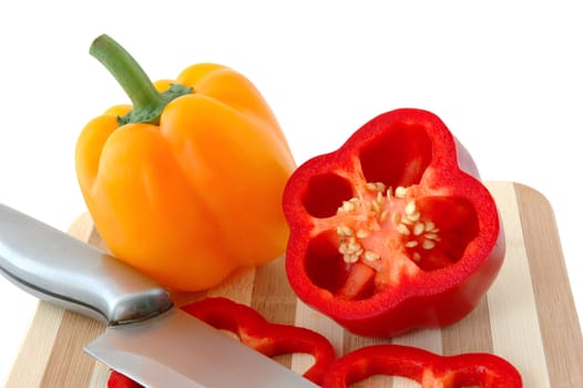 Red and yellow paprika on bamboo cutting board.