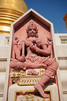 statue and golden pagoda at thai temple