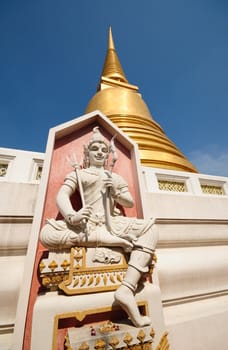 statue and golden pagoda at thai temple
