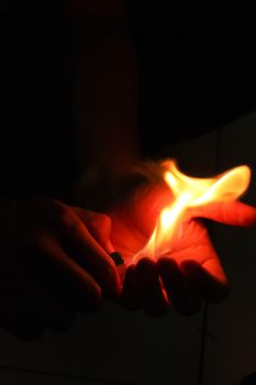 Open hands catching a match burning flame.
