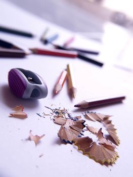 Colorful pencils shavings on a white background.