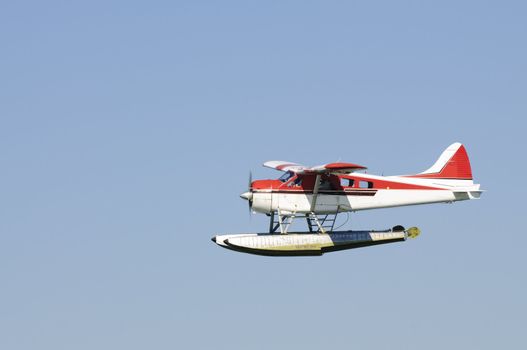 Floatplane / Seaplane flying in a blue sky in Canada