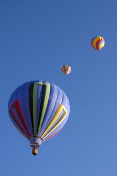colorful balloons rising at dawn in the cold air at the Taos hot air balloon festival