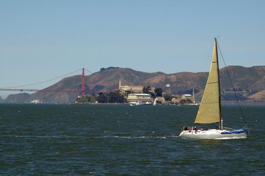 Yatch sailing on San Francisco bay with the Golden Gate bridge and Alcatraz in the distance with Marin Headlands behind