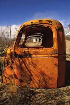 Abandoned grunge, a truck cab with an abandoned cabin through the window in Death Valley, California