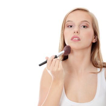 The beautiful young woman does a make-up, isolated on a white background