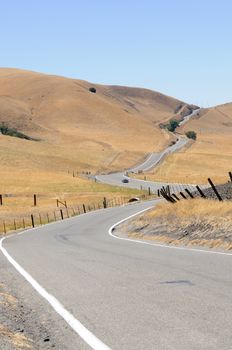 A sportster negotiating a  long winding country road in California