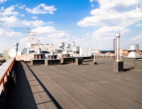 Roof of a modern residential apartment building with heating and ventilation equipment  and satellite dishes