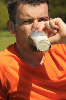 man is drinking fresh glass of milk in the natural background